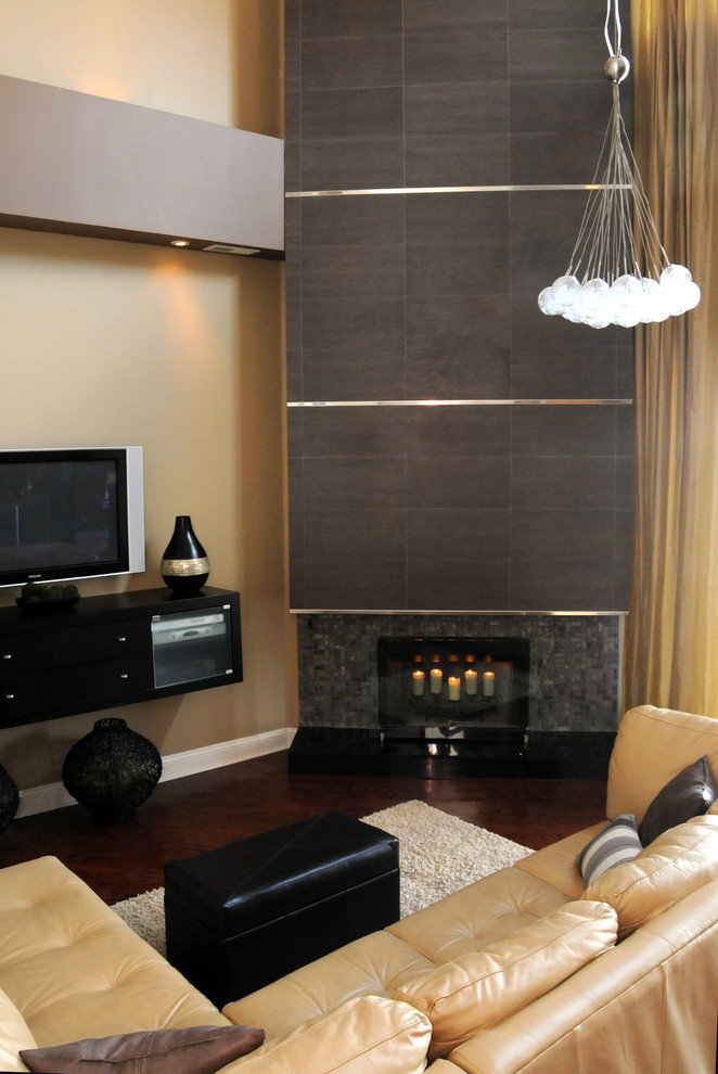 Modernes Wohnzimmer mit beiger Wandfarbe, dunklem Holzboden, Eckkamin, Kaminumrandung aus Stein und freistehendem TV in Jacksonville