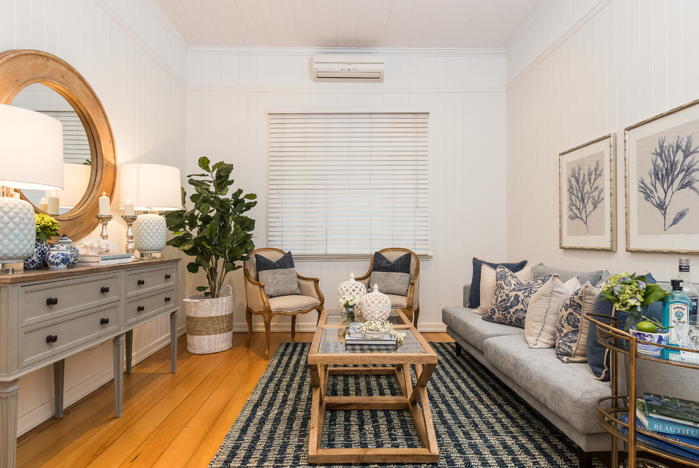Foto di un soggiorno stile marino chiuso con sala formale, pareti bianche, pavimento in legno massello medio e pavimento beige
