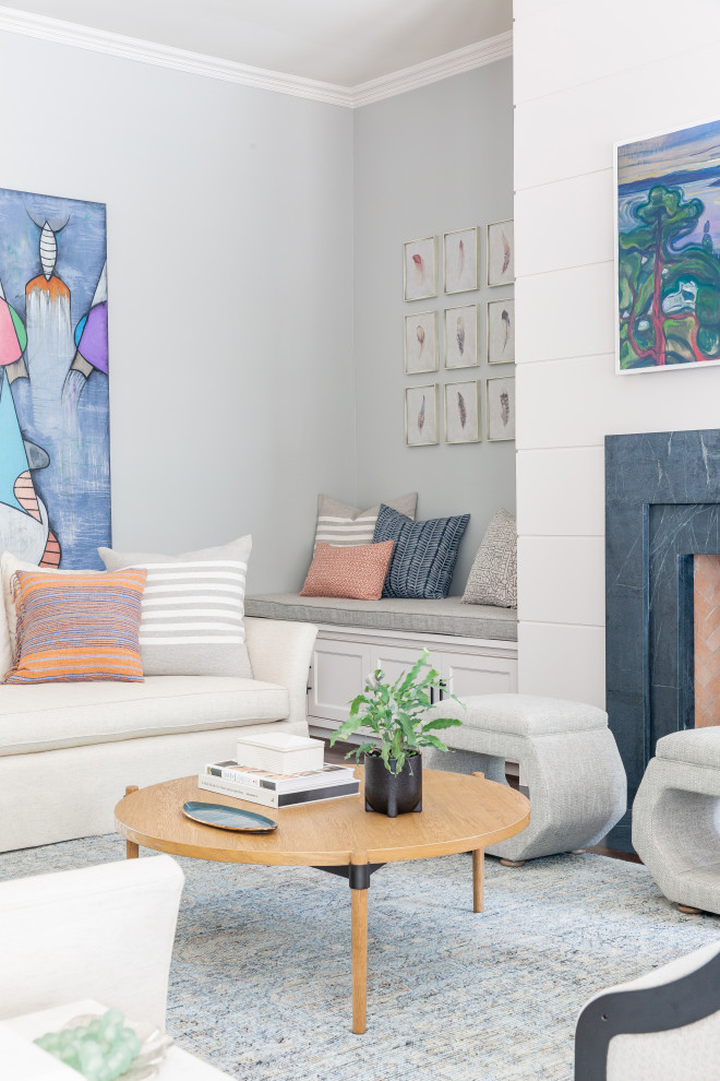 Пример оригинального дизайна: большая открытая гостиная комната в стиле неоклассика (современная классика) с серыми стенами, темным паркетным полом, стандартным камином, фасадом камина из камня, телевизором на стене и коричневым полом