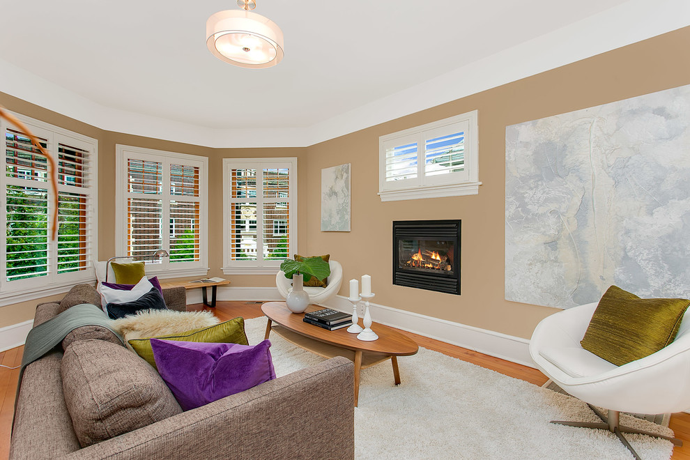 Exemple d'un grand salon moderne ouvert avec un mur beige, parquet clair, une cheminée standard et un manteau de cheminée en plâtre.