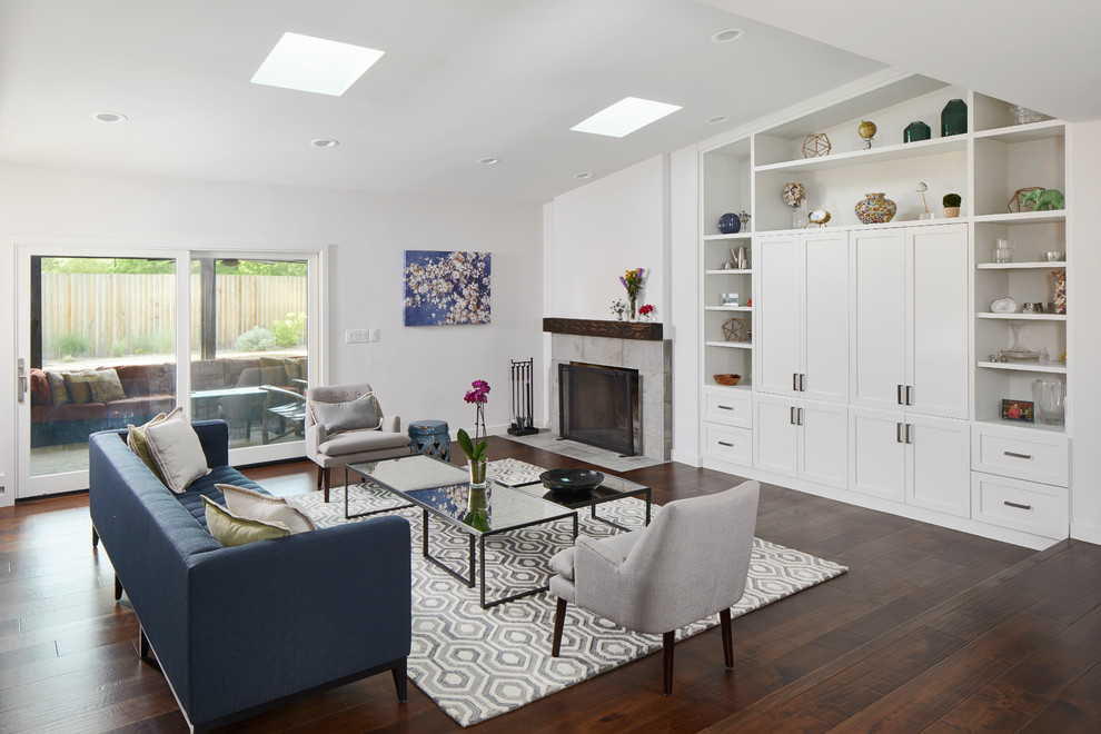Mittelgroßes, Offenes Modernes Wohnzimmer mit weißer Wandfarbe, dunklem Holzboden, Kamin, gefliester Kaminumrandung und braunem Boden in Austin