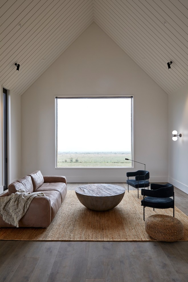 Imagen de salón abierto minimalista con paredes grises, suelo de madera oscura y suelo marrón