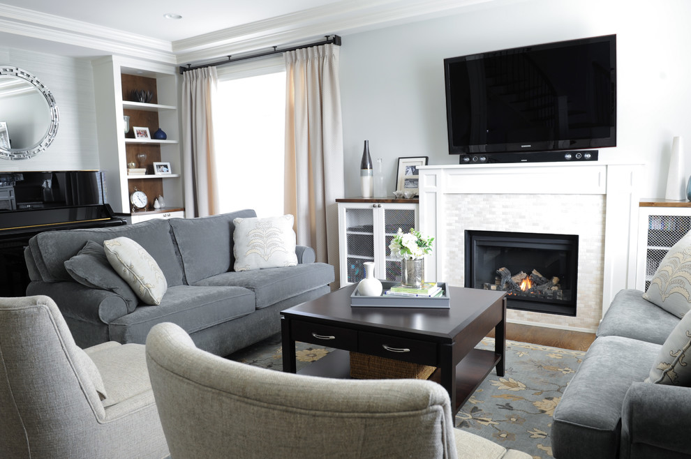 Idee per un soggiorno chic di medie dimensioni con pareti blu, pavimento in legno massello medio, camino classico e TV a parete