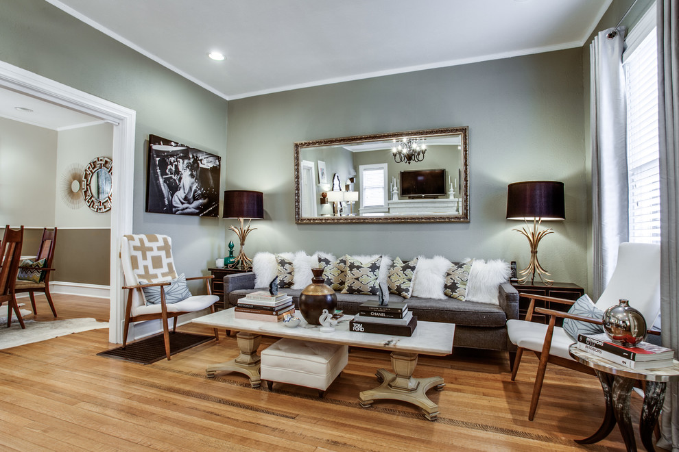 На фото: изолированная гостиная комната среднего размера в стиле фьюжн с серыми стенами, светлым паркетным полом, стандартным камином, отдельно стоящим телевизором и фасадом камина из кирпича