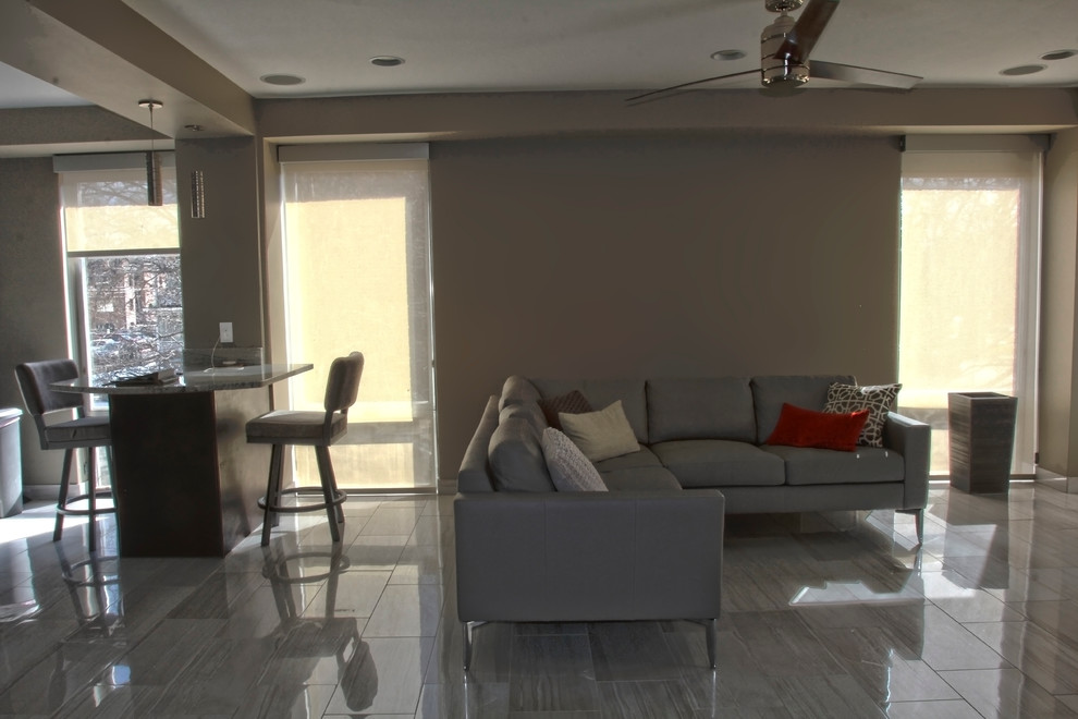 Mittelgroßes, Repräsentatives, Fernseherloses, Offenes Modernes Wohnzimmer mit brauner Wandfarbe, Porzellan-Bodenfliesen und grauem Boden in Omaha