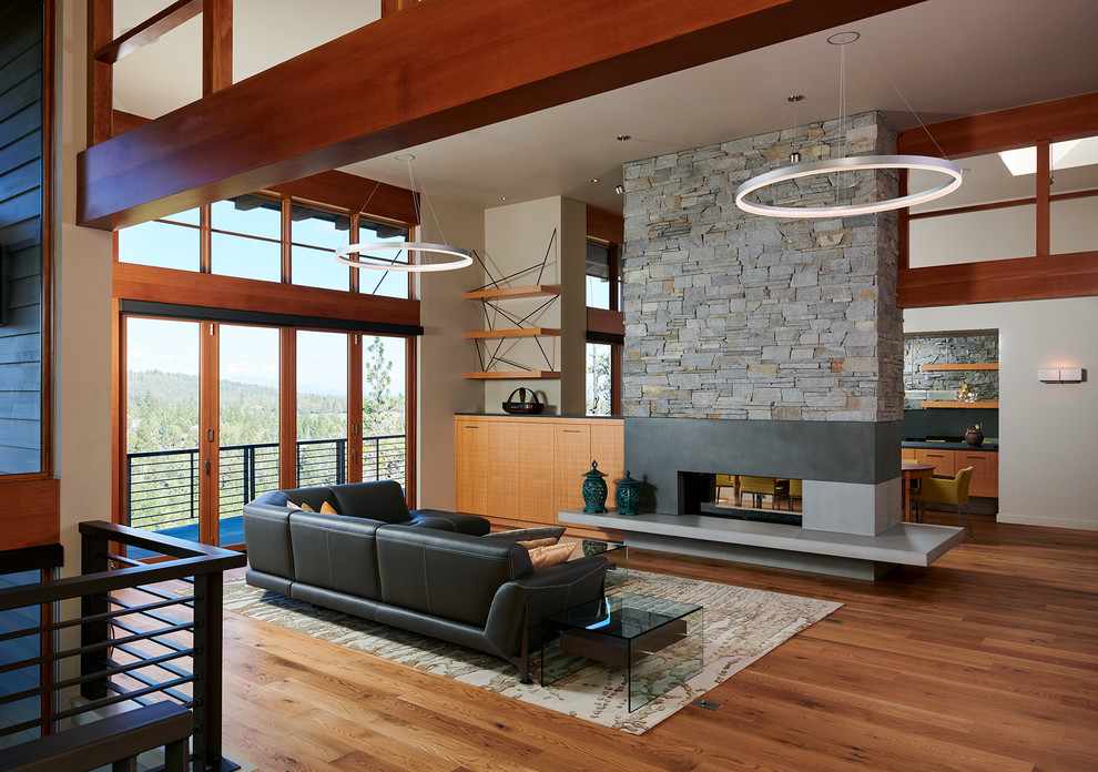 Inspiration for a contemporary open concept medium tone wood floor and brown floor living room remodel in Other with a two-sided fireplace and no tv