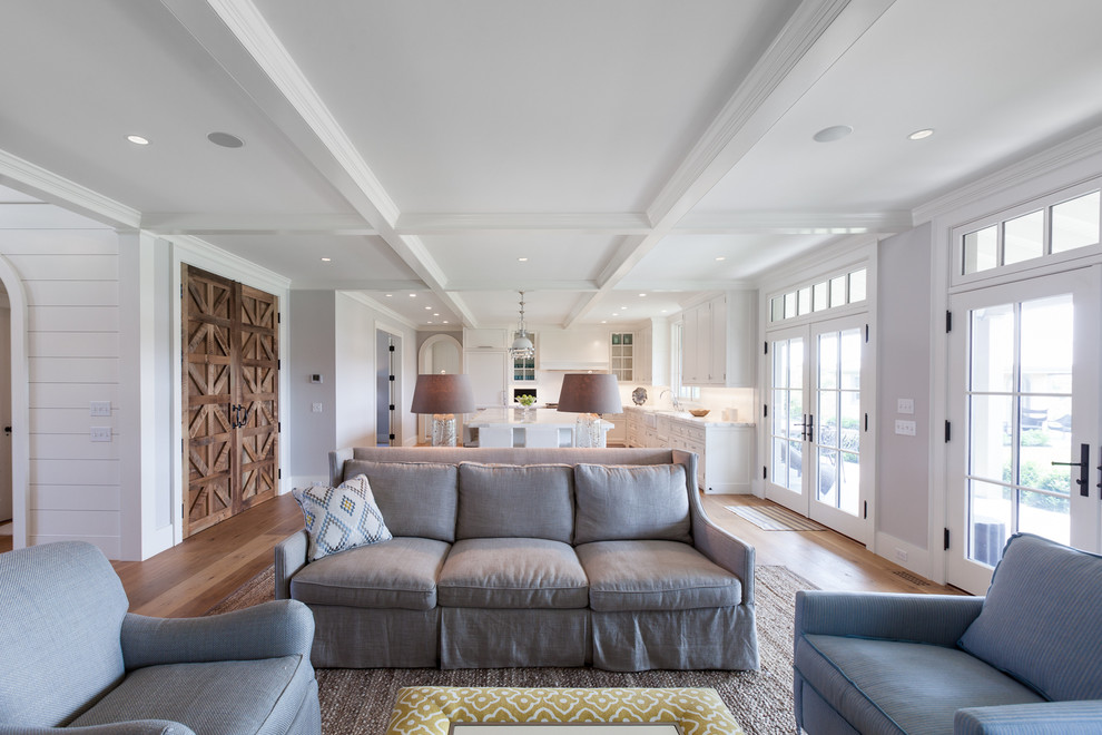 This is an example of a large coastal formal open plan living room in Boston with grey walls, medium hardwood flooring, a standard fireplace, a wooden fireplace surround and no tv.