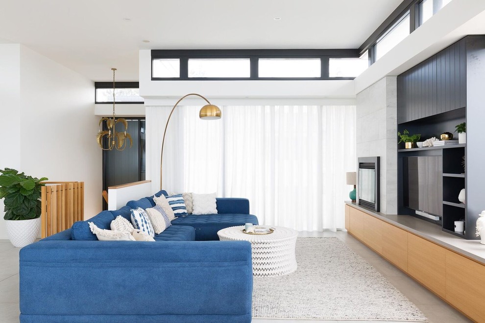 Contemporary open plan living room in Sydney with white walls, ceramic flooring, a tiled fireplace surround, a built-in media unit and grey floors.