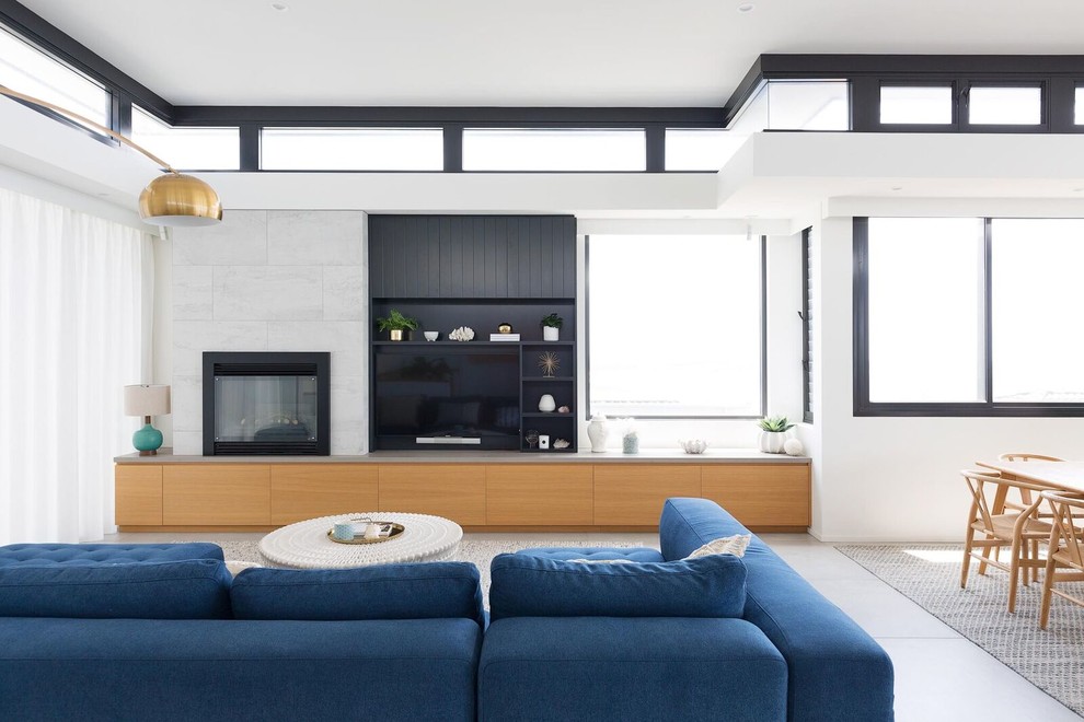 シドニーにあるコンテンポラリースタイルのおしゃれなLDK (白い壁、セラミックタイルの床、タイルの暖炉まわり、グレーの床、壁掛け型テレビ) の写真