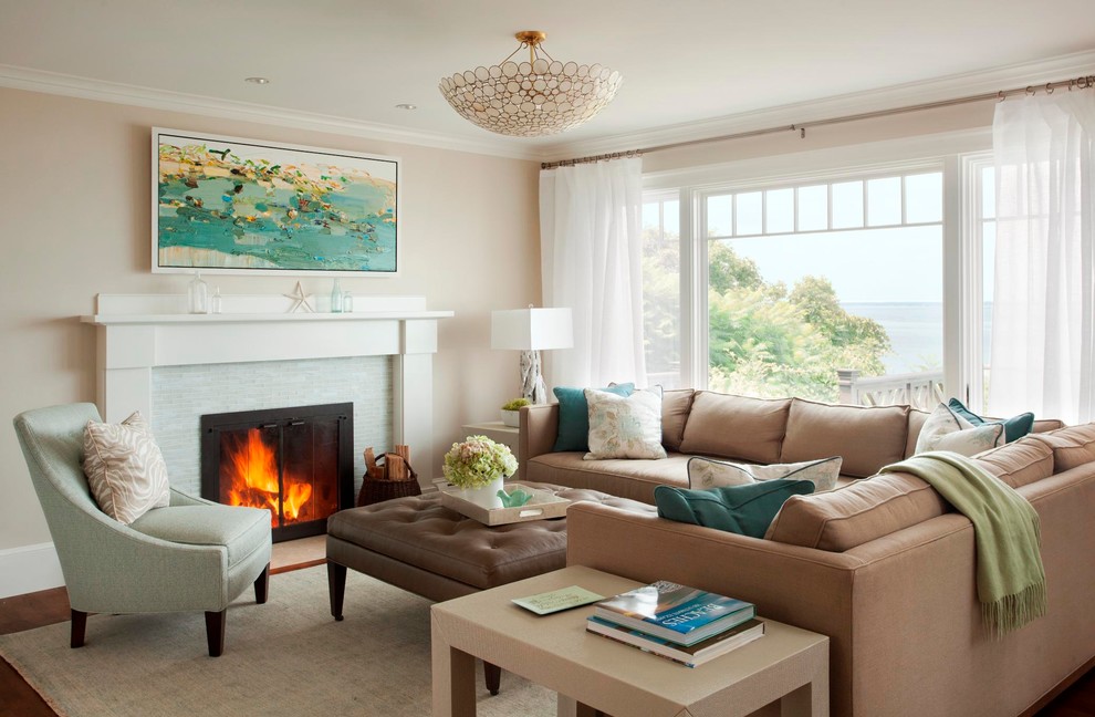 Inspiration for a large beach style open plan living room in Boston with a standard fireplace, a tiled fireplace surround, medium hardwood flooring, beige walls and feature lighting.