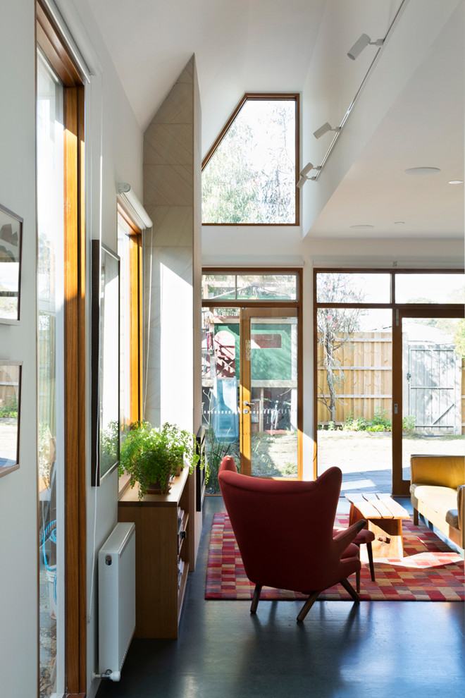 Imagen de salón abierto actual con paredes blancas, suelo de linóleo, marco de chimenea de piedra y suelo turquesa