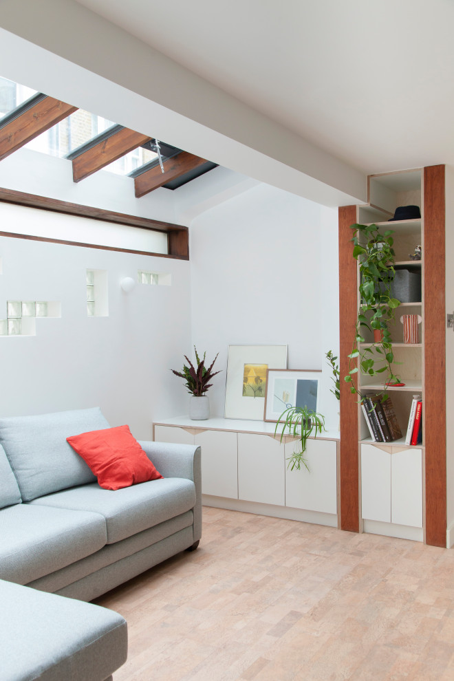 Свежая идея для дизайна: маленькая открытая гостиная комната в современном стиле с с книжными шкафами и полками, белыми стенами, пробковым полом и коричневым полом без телевизора для на участке и в саду - отличное фото интерьера