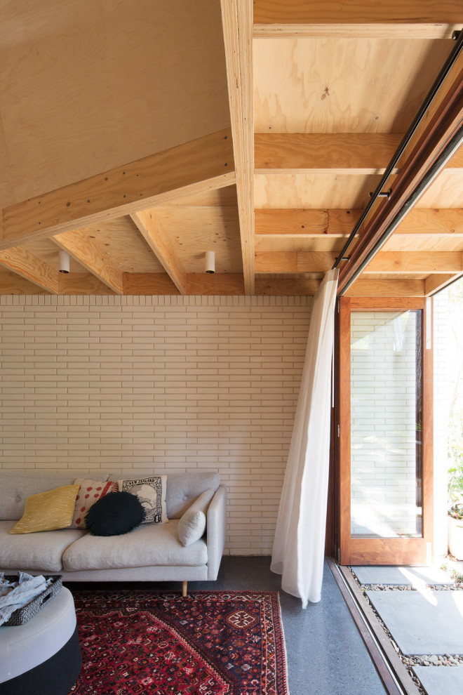 Aménagement d'un petit salon mansardé ou avec mezzanine contemporain en bois avec sol en béton ciré, un téléviseur fixé au mur et un plafond en lambris de bois.