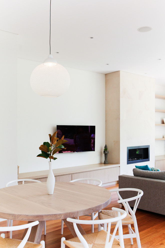 Mittelgroßes, Offenes Maritimes Wohnzimmer mit weißer Wandfarbe, hellem Holzboden, Kamin, Kaminumrandung aus Stein und TV-Wand in Sydney