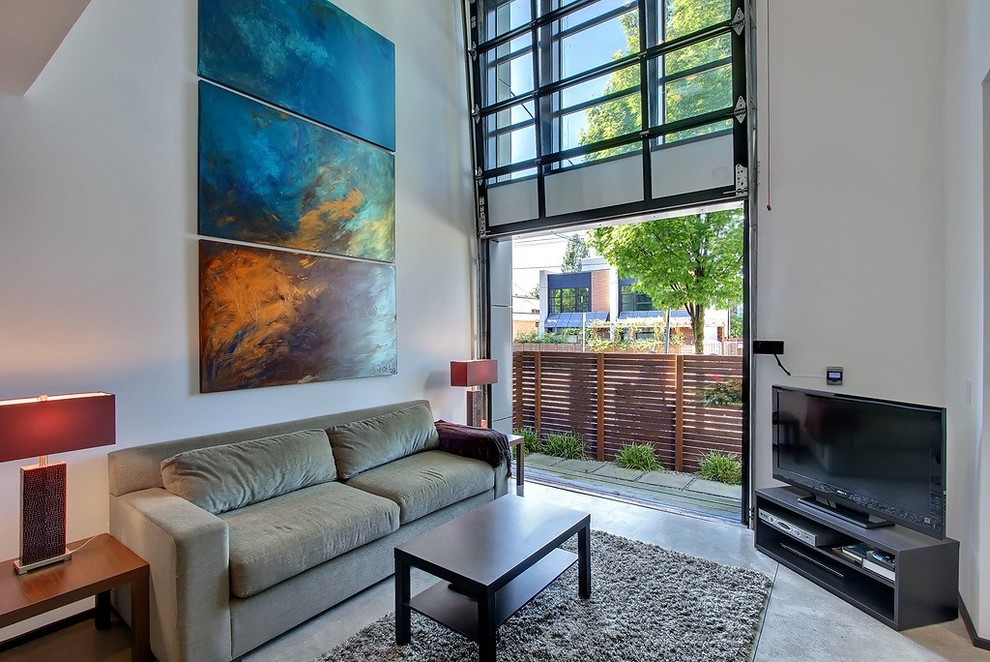 На фото: гостиная комната в стиле модернизм с бетонным полом, отдельно стоящим телевизором и коричневым диваном с
