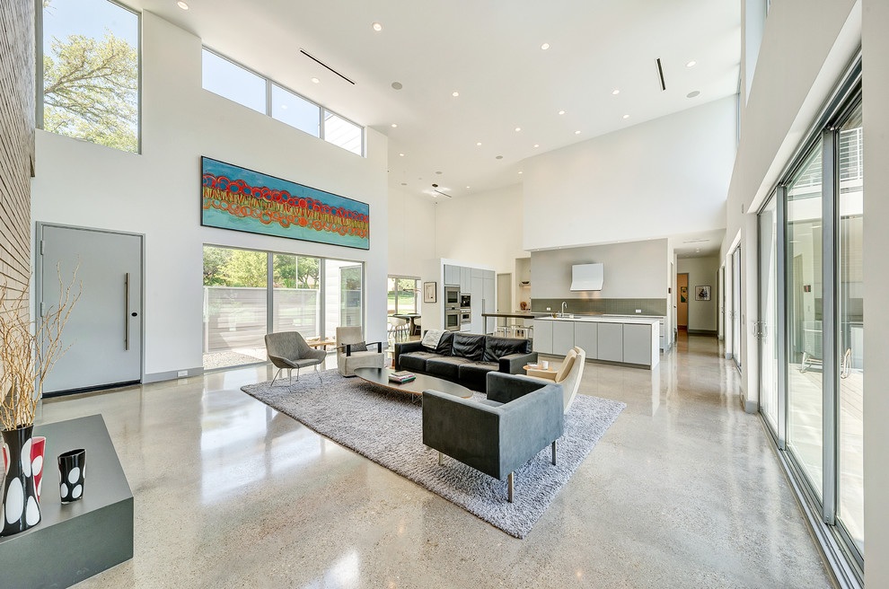Example of a huge minimalist formal and open concept concrete floor and multicolored floor living room design in Dallas with white walls, a hanging fireplace, a brick fireplace and a wall-mounted tv