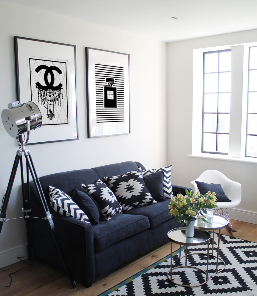 Living room - small contemporary open concept medium tone wood floor living room idea in London with white walls, no fireplace and a tv stand