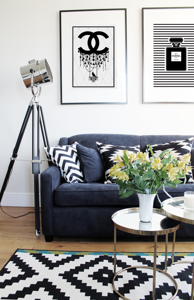 This is an example of a small contemporary open plan living room in London with white walls, medium hardwood flooring and no fireplace.