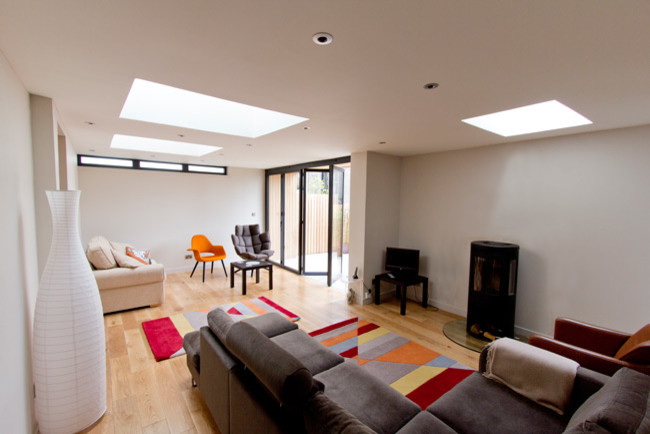 Mittelgroßes, Abgetrenntes Modernes Wohnzimmer mit beiger Wandfarbe, hellem Holzboden und Kamin in Glasgow