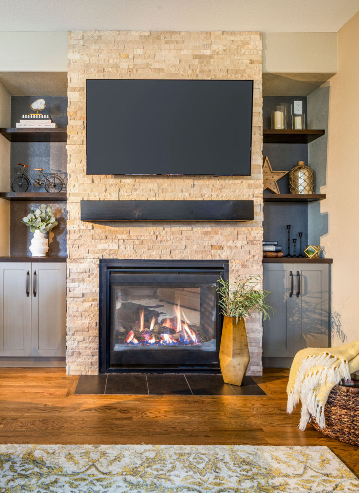 デンバーにある高級な中くらいなトランジショナルスタイルのおしゃれなLDK (ベージュの壁、無垢フローリング、標準型暖炉、積石の暖炉まわり、壁掛け型テレビ、茶色い床) の写真