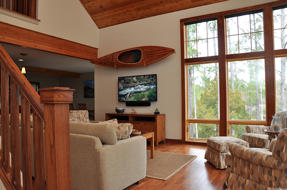 Ispirazione per un soggiorno minimal aperto con pareti beige, pavimento in legno massello medio e TV a parete