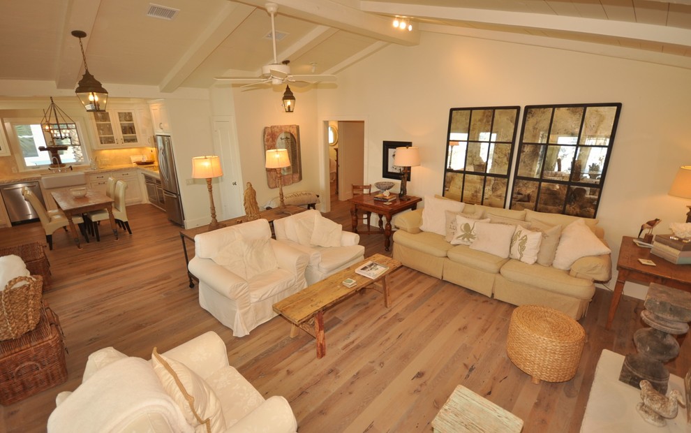 Offenes Maritimes Wohnzimmer mit beiger Wandfarbe, hellem Holzboden, Kamin, Kaminumrandung aus Stein und Multimediawand in Houston