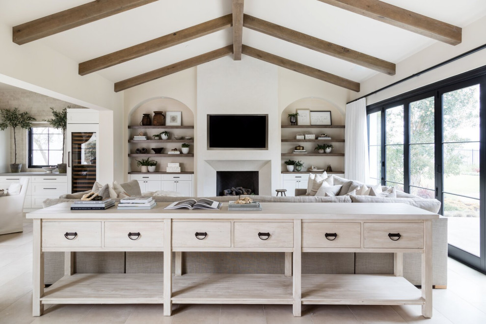 Offenes Maritimes Wohnzimmer mit weißer Wandfarbe, TV-Wand, grauem Boden, freigelegten Dachbalken und gewölbter Decke in Orange County