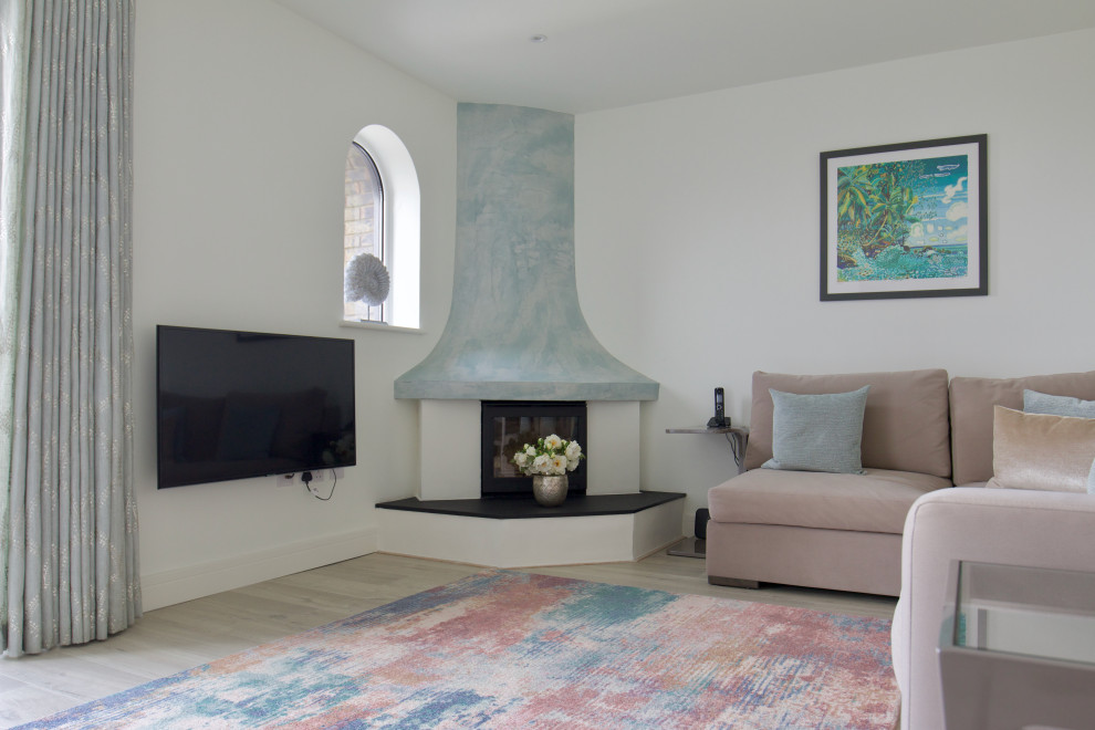 Medium sized contemporary enclosed living room in Hampshire with white walls, laminate floors, a plastered fireplace surround and beige floors.