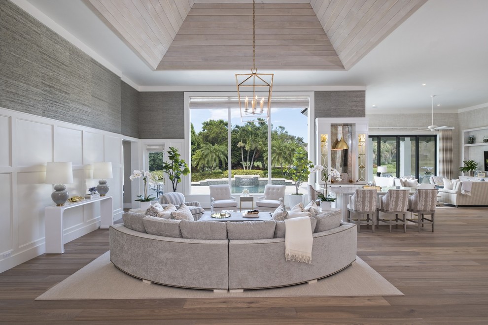 Offenes Maritimes Wohnzimmer mit grauer Wandfarbe, hellem Holzboden und beigem Boden in Miami