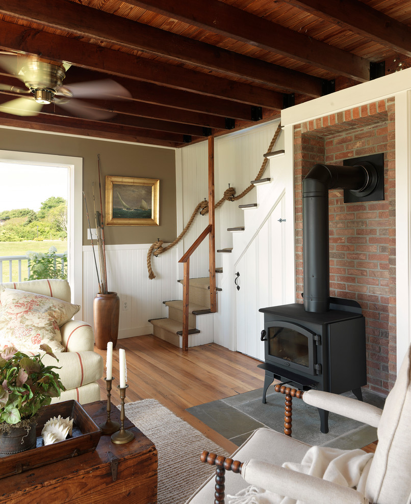 Inspiration for a coastal medium tone wood floor living room remodel in Providence with brown walls and a wood stove