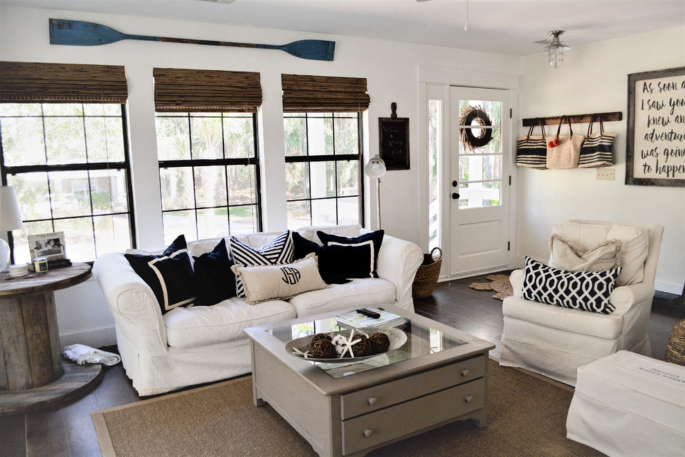 Kleines, Offenes Maritimes Wohnzimmer mit weißer Wandfarbe, dunklem Holzboden, TV-Wand und braunem Boden in Charleston