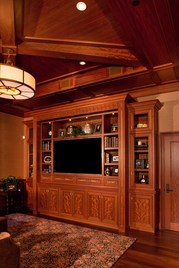 Diseño de salón para visitas cerrado tradicional de tamaño medio con pared multimedia, paredes beige, suelo de madera en tonos medios y suelo marrón