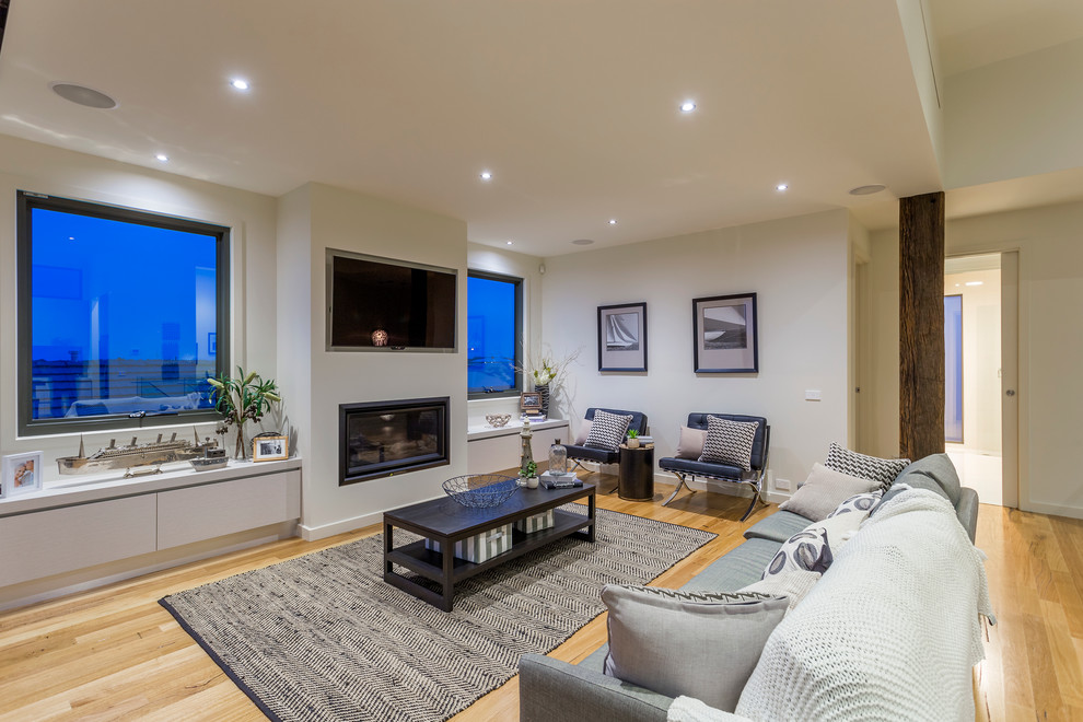 Repräsentatives, Offenes Modernes Wohnzimmer mit weißer Wandfarbe, braunem Holzboden, Kaminumrandung aus Backstein und TV-Wand in Geelong