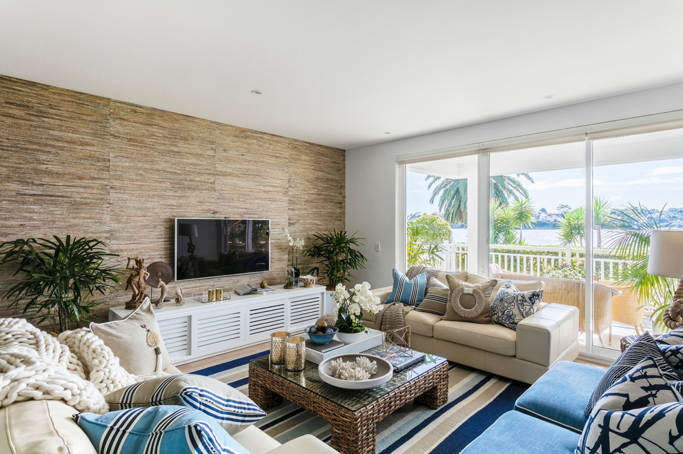 Example of a mid-sized beach style open concept light wood floor living room design in Sydney with white walls, no fireplace and a wall-mounted tv