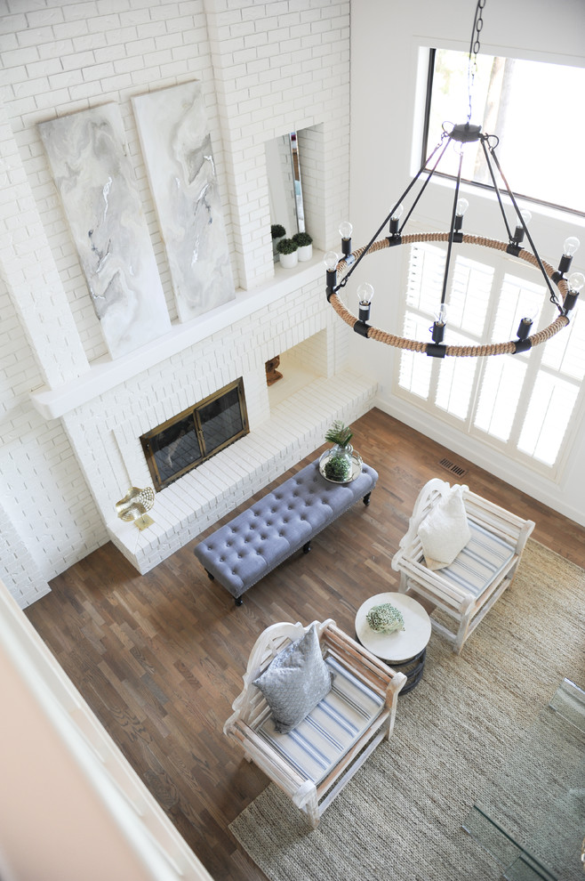 Mittelgroßes Maritimes Wohnzimmer im Loft-Stil mit weißer Wandfarbe, hellem Holzboden, Tunnelkamin, Kaminumrandung aus Backstein, braunem Boden und Holzdecke in Vancouver