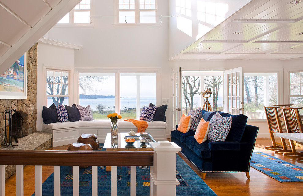 Example of a beach style open concept medium tone wood floor living room design in Bridgeport with white walls, a standard fireplace, a stone fireplace and no tv