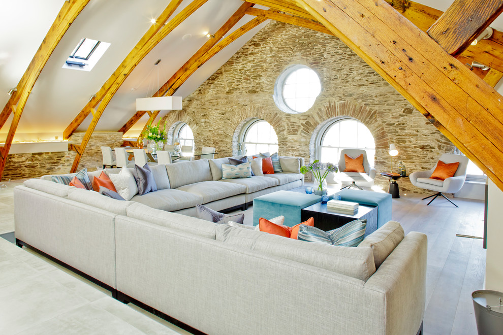 Diseño de salón abierto de estilo de casa de campo con suelo de madera clara, suelo beige y piedra
