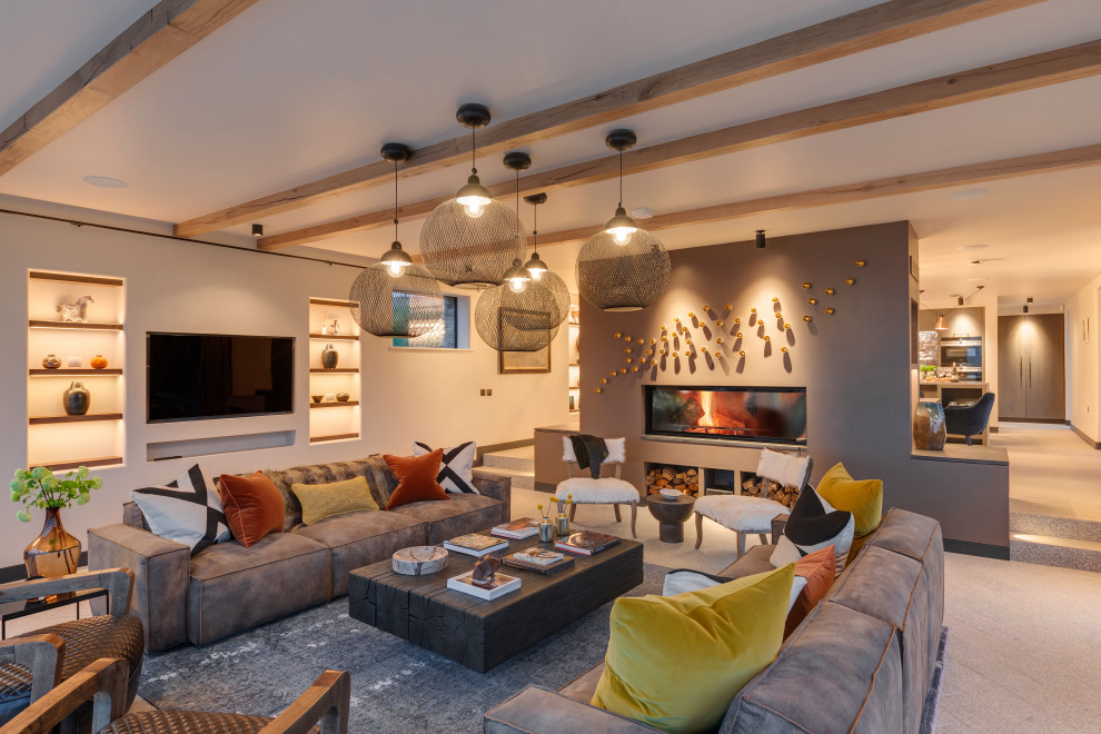Photo of a contemporary open plan living room in Cornwall with grey walls, a ribbon fireplace, a wall mounted tv, grey floors and exposed beams.