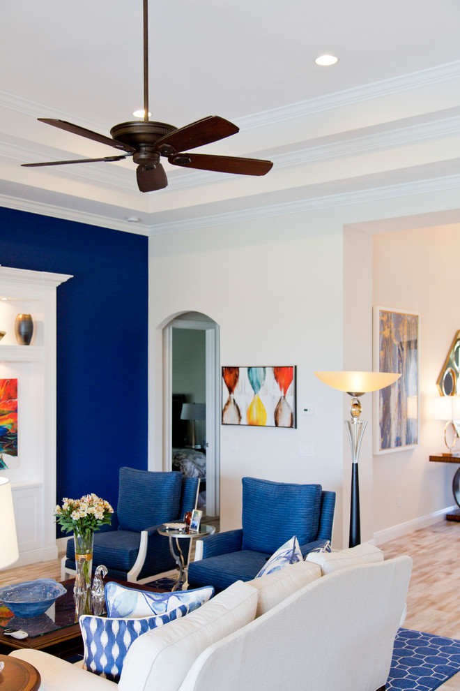 Ejemplo de salón para visitas abierto costero grande con paredes azules, suelo de madera en tonos medios, televisor colgado en la pared y suelo marrón