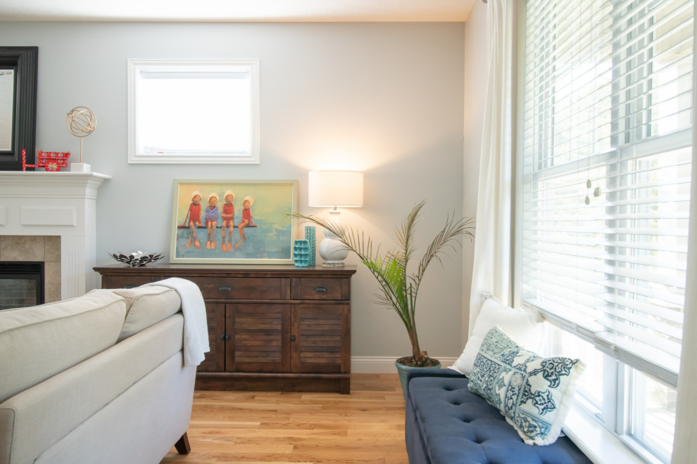 インディアナポリスにある低価格の広いトラディショナルスタイルのおしゃれなLDK (青い壁、無垢フローリング、標準型暖炉、木材の暖炉まわり、据え置き型テレビ、オレンジの床) の写真