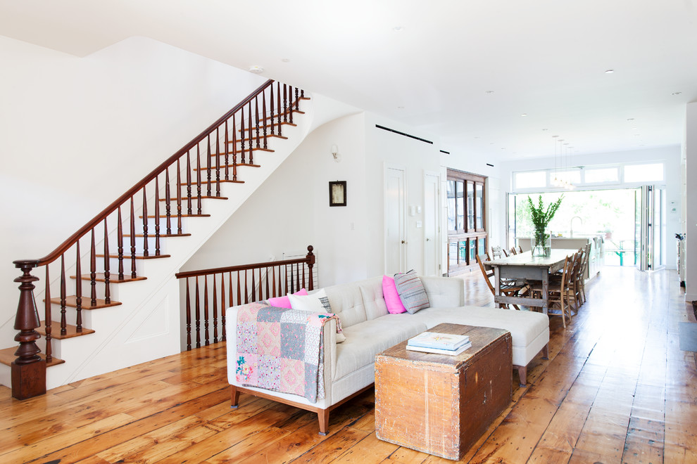 Mittelgroßes, Offenes Modernes Wohnzimmer mit weißer Wandfarbe, braunem Holzboden und braunem Boden in New York