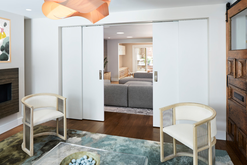 Ispirazione per un soggiorno minimalista di medie dimensioni con pareti beige, pavimento in legno massello medio, cornice del camino in pietra e pavimento marrone