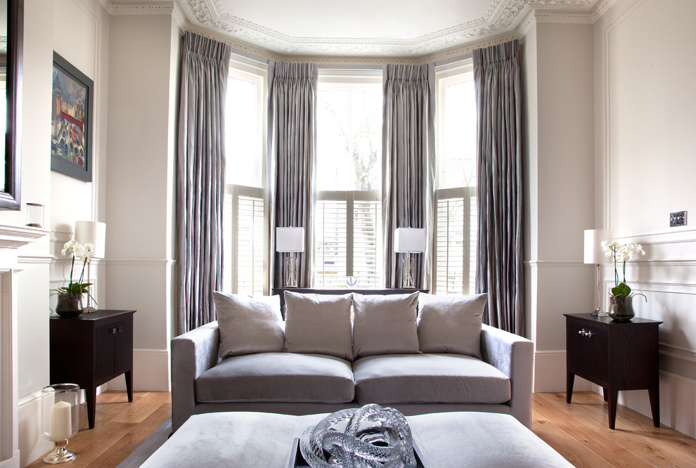 Example of an ornate formal medium tone wood floor living room design in London with gray walls