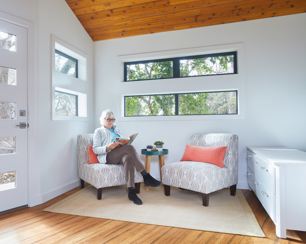 Esempio di un piccolo soggiorno minimalista aperto con pareti bianche e pavimento in bambù