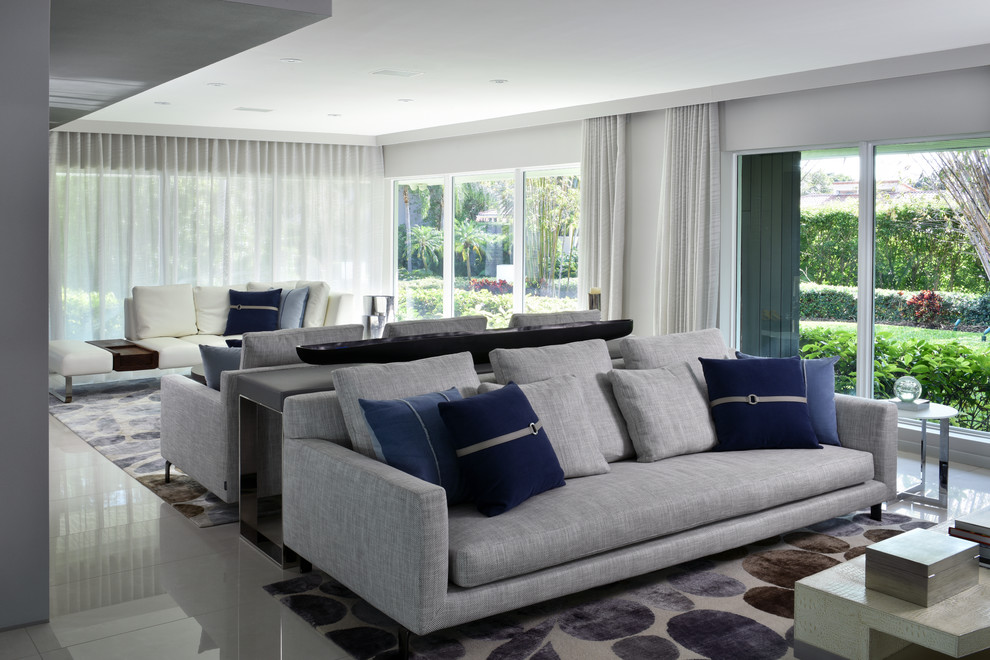 Design ideas for a large contemporary formal open plan living room in Miami with grey walls, limestone flooring and a tiled fireplace surround.