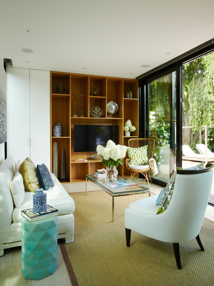 Foto di un piccolo soggiorno contemporaneo aperto con libreria, pareti gialle, parquet chiaro e TV a parete