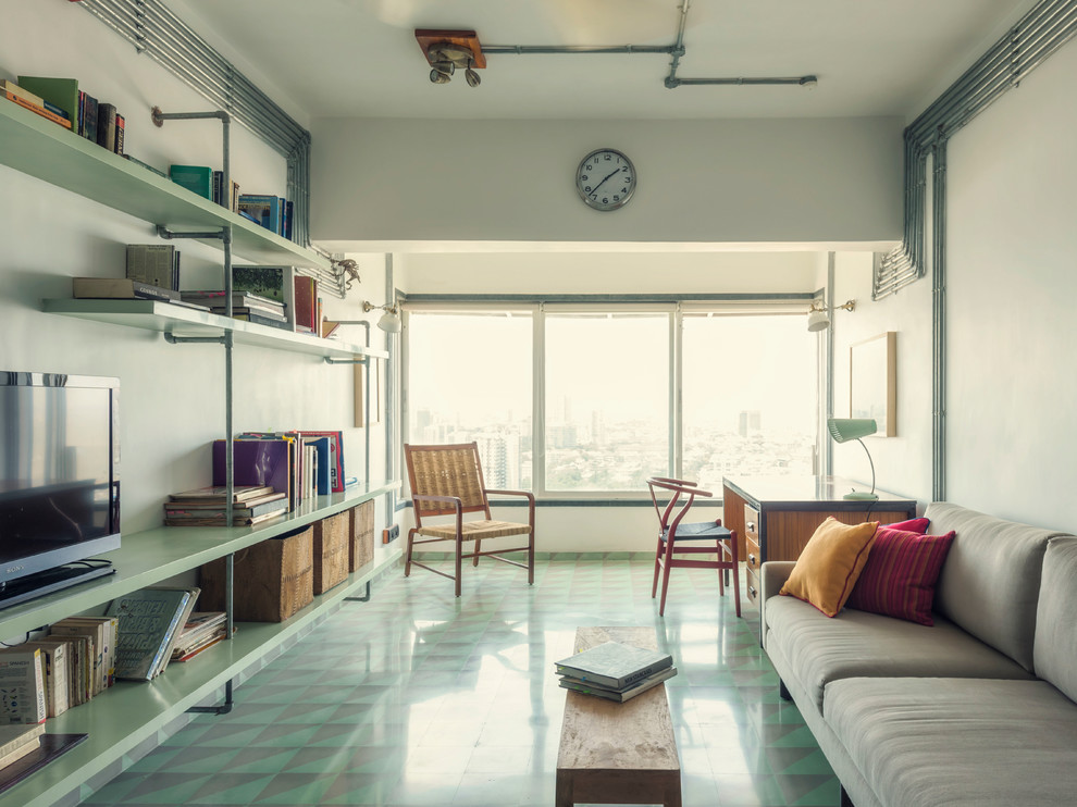 Immagine di un soggiorno industriale di medie dimensioni e chiuso con libreria, pareti bianche, pavimento con piastrelle in ceramica, TV autoportante e pavimento verde