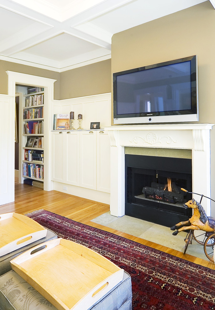 Diseño de salón clásico con paredes beige y televisor colgado en la pared