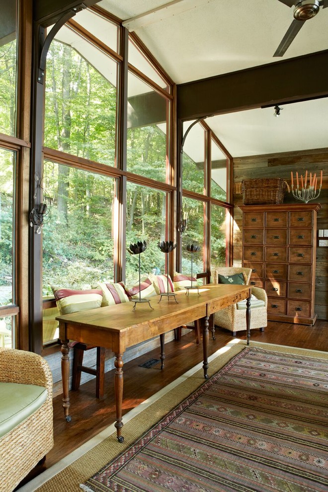 Immagine di un grande soggiorno country aperto con pareti marroni, pavimento in legno massello medio e pavimento marrone