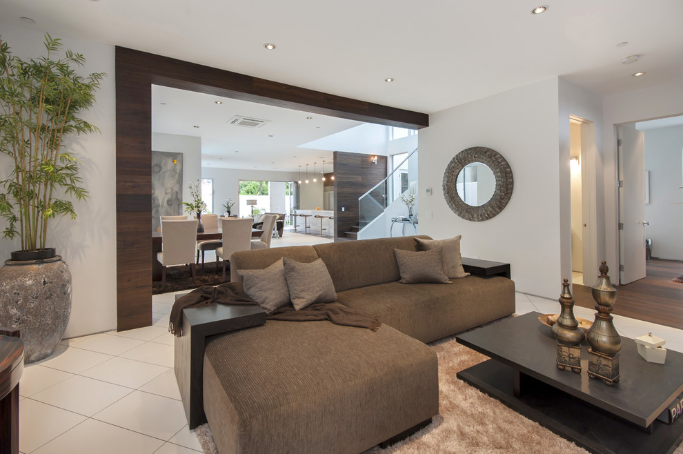 Immagine di un soggiorno minimal aperto e di medie dimensioni con pareti bianche, pavimento in gres porcellanato e nessuna TV